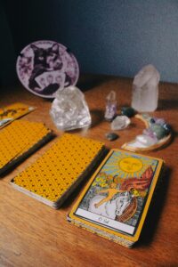 Tarot cards and crystals on wooden table symbolize mysticism and divination.