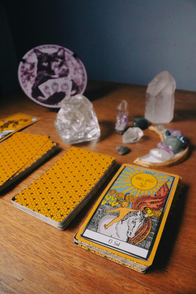 Tarot cards and crystals on wooden table symbolize mysticism and divination.